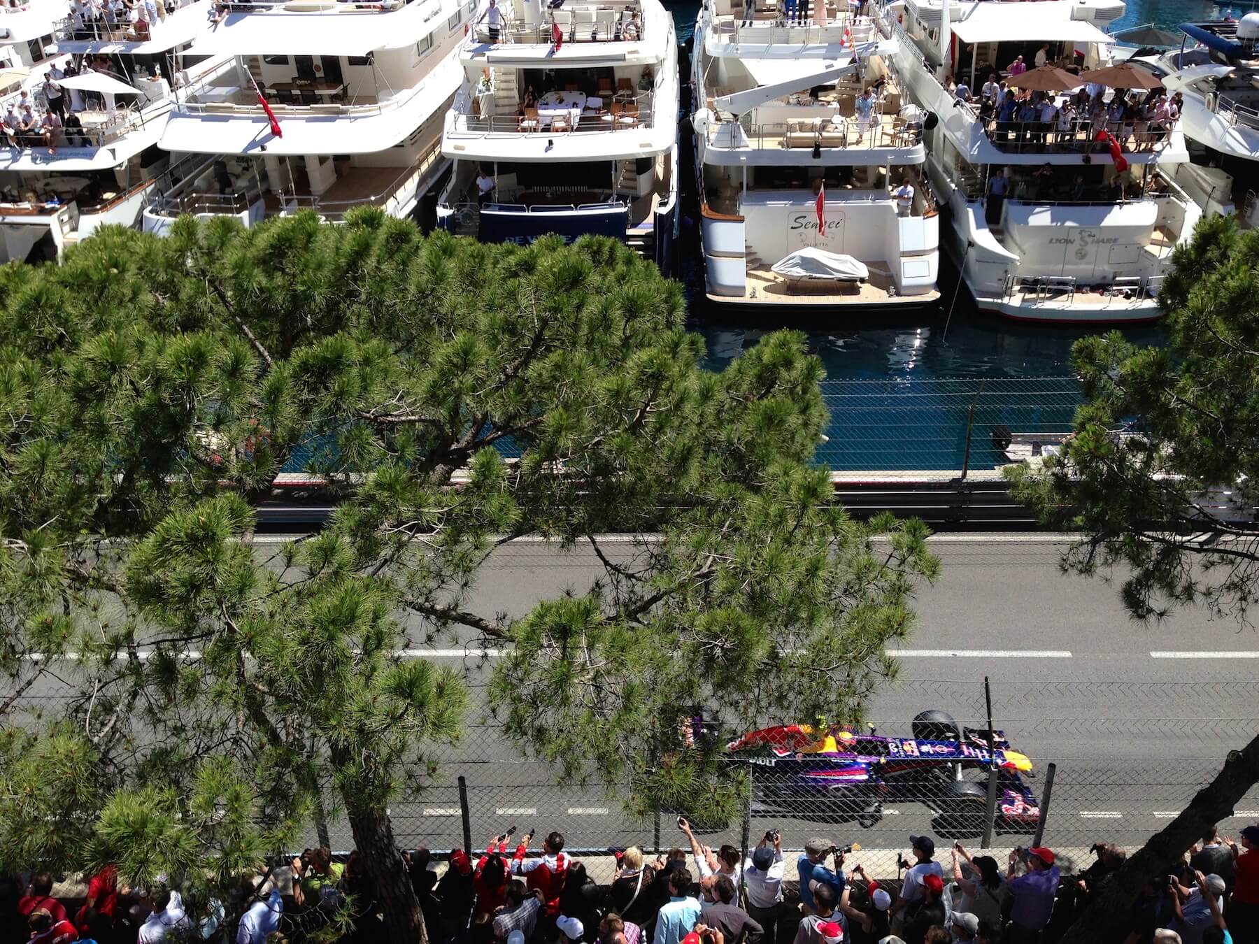 Red Bull F1 car in front of luxury yachts at Monaco GP