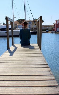 Gil sitting on end of wooden gangway in Port Grimaud