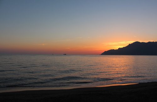 Sun setting behind cliff face in Salerno Italy