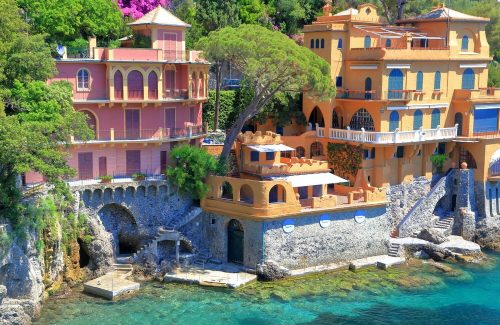Pink and orange villas with steps leading down to crystal waters below, Portofino